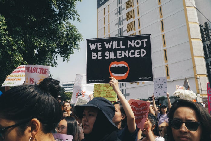 people holding signs at a protest for women's rights