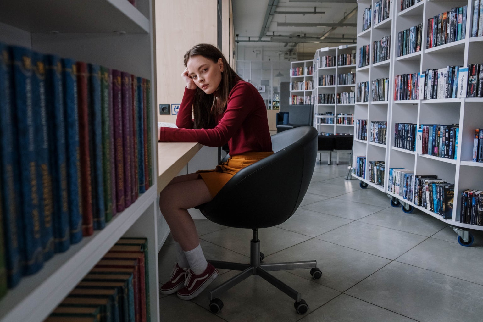 young person sad sitting alone in library