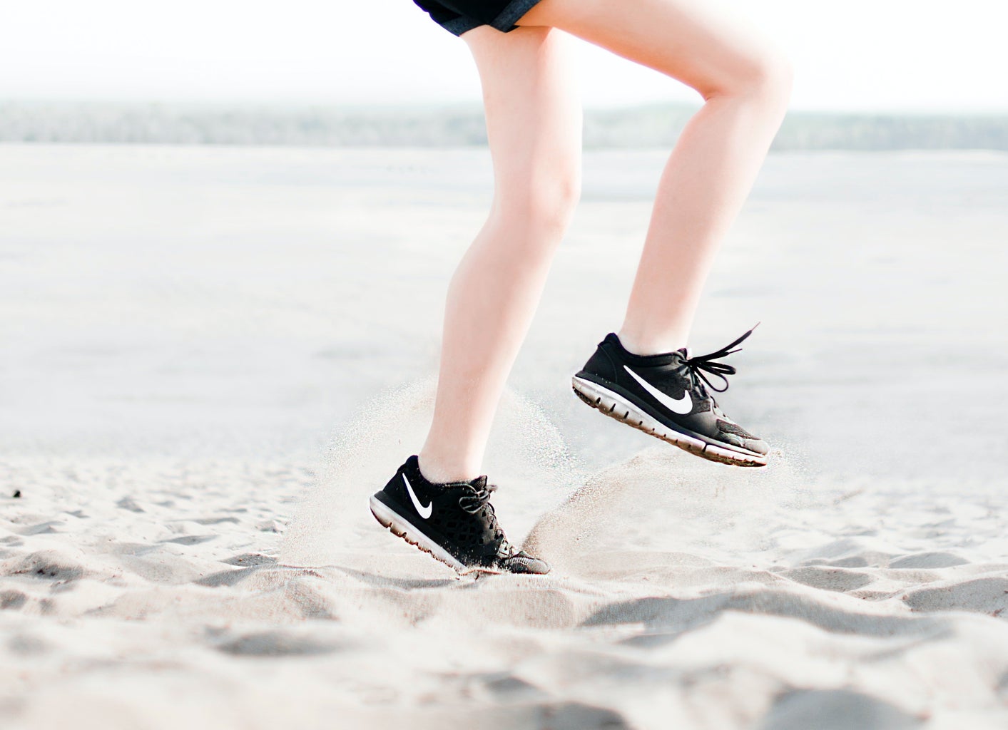 Woman Wearing Pair of Black Nike Running Shoes