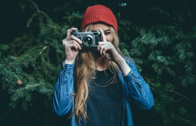 blonde woman holding camera outside