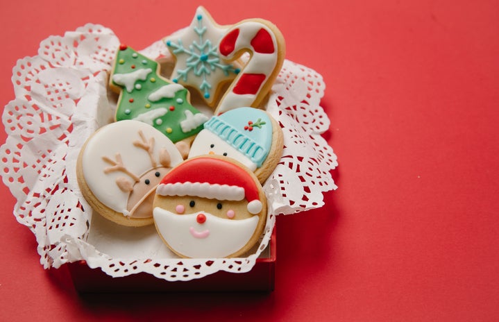 Christmas themed sugar cookies in a white laced basket with a red background