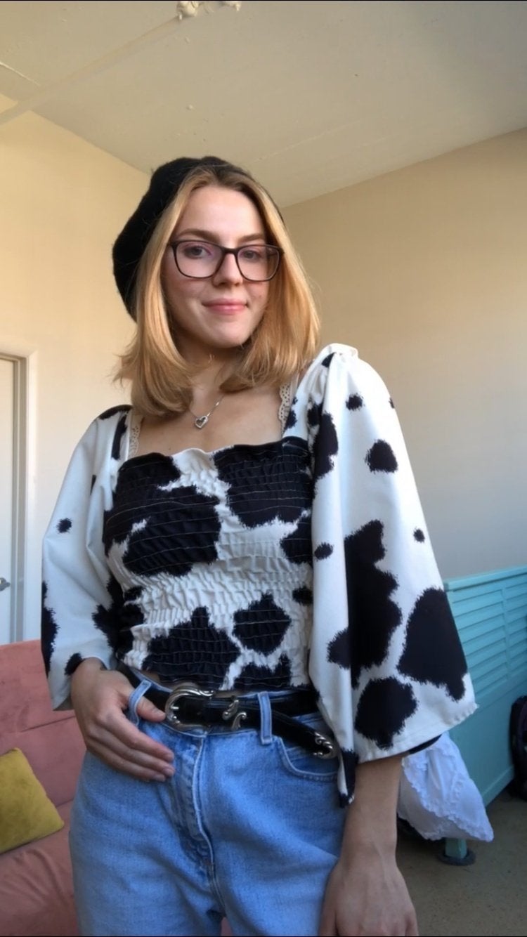 Girl in cow-print top with black beret