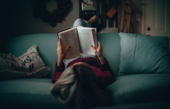 A woman reading on a couch.