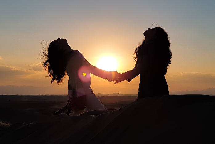silhouette photo of two women holding hands