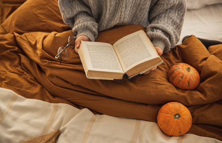 woman reading a book pumpkins