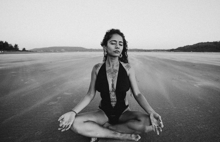 woman in black swimsuit meditating