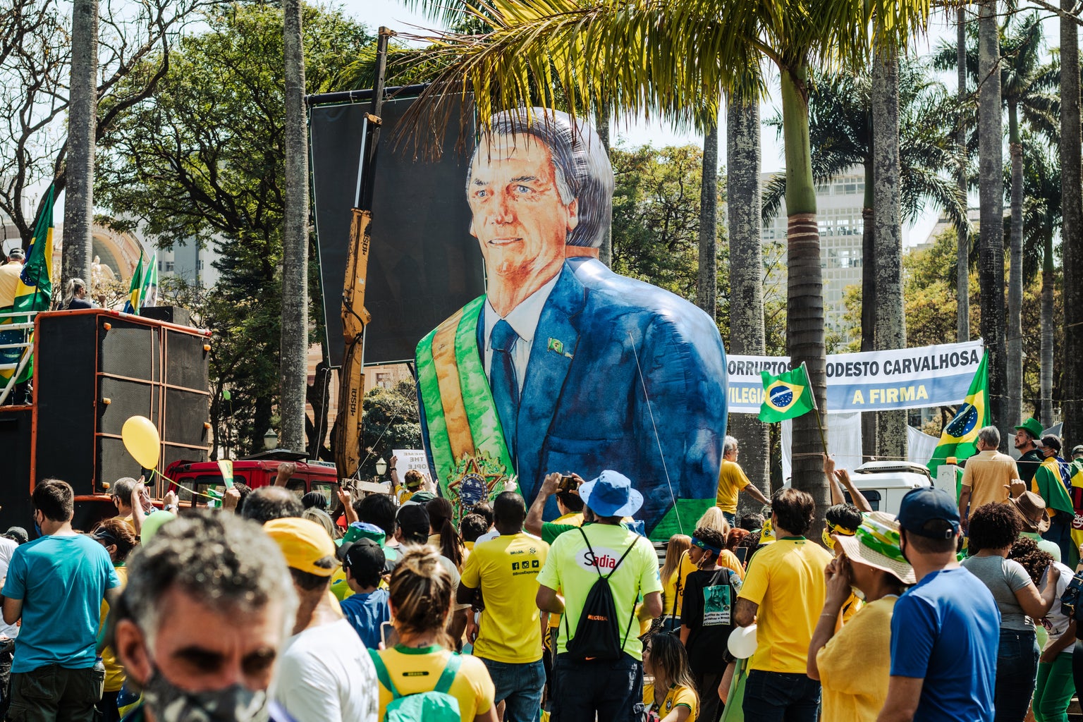 a Bolsonaro statue in the middle of a crown at the streets