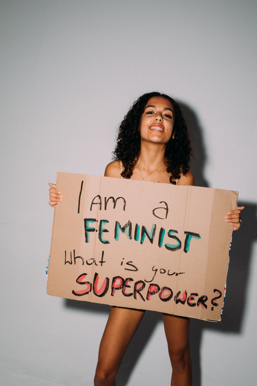 woman holding sign with writing \