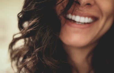 woman smiling half face brown hair