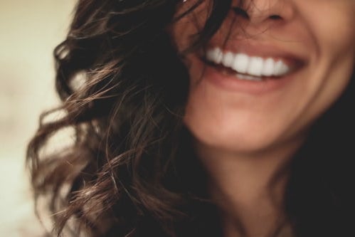 woman smiling half face brown hair