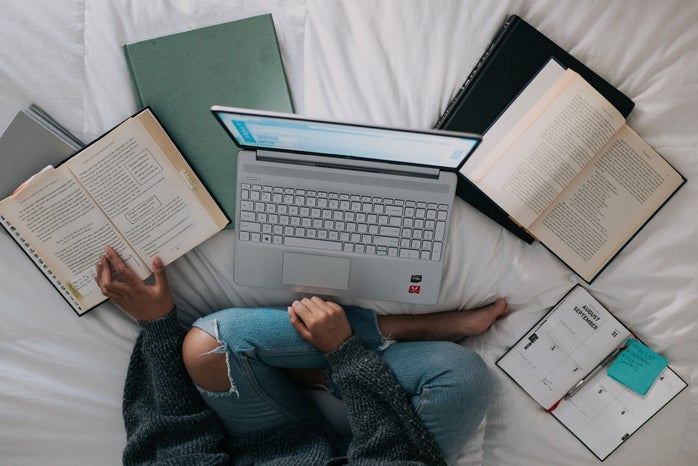 Woman sitting on bed with laptop and books by Windows on Unsplash?width=698&height=466&fit=crop&auto=webp