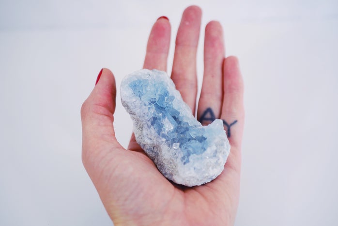 Blue and white crystal in the palm of a hand