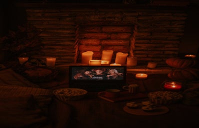 laptop playing "Hocus Pocus" in a room with candles and popcorn