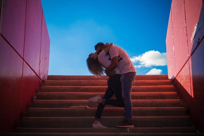man and woman kissing on stairs