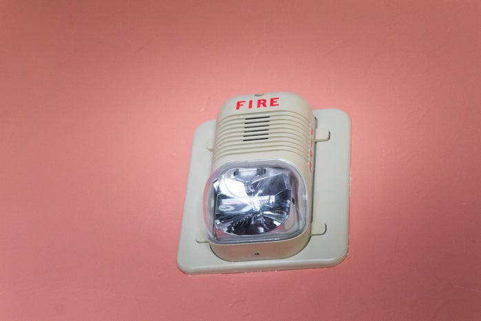 A fire alarm on a pink background