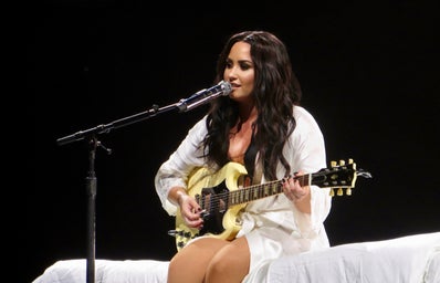 demi lovato playing guitar on stage