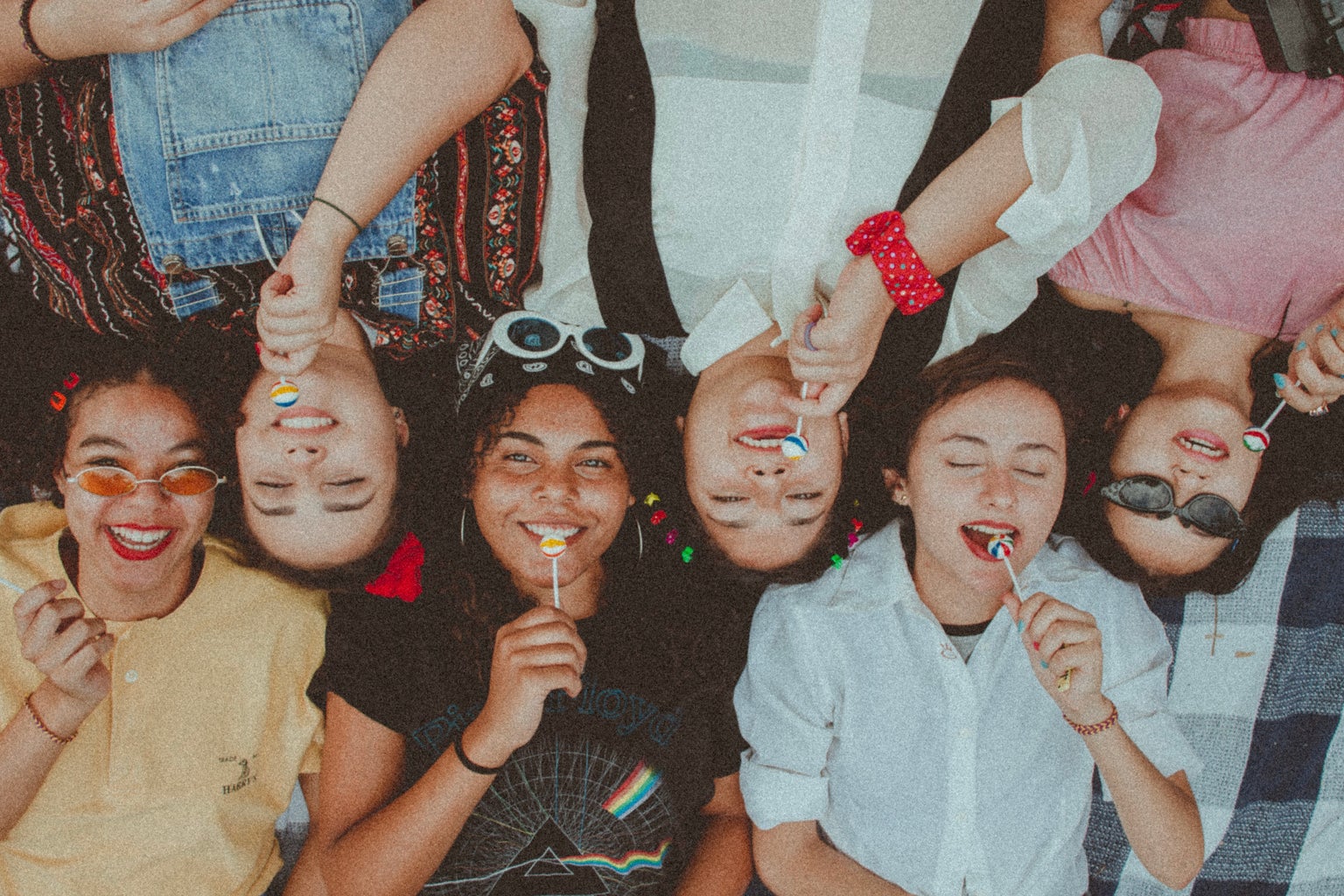 Group of friends side by side with lollipops