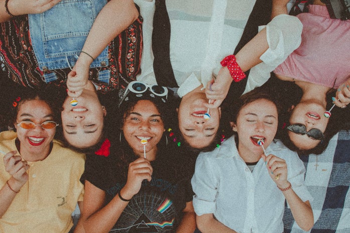 Group of friends side by side with lollipops