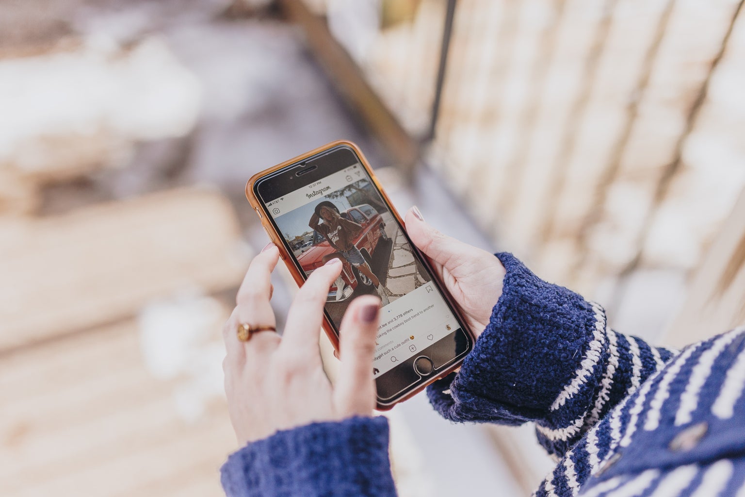 Woman looks at a photo on Instagram on her phone.