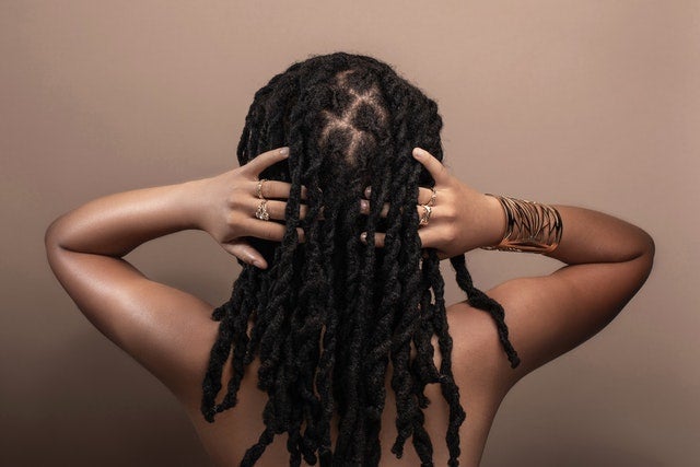 a black woman\'s bare back with dread locs