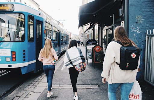 girls walking around Oslo beside a tram