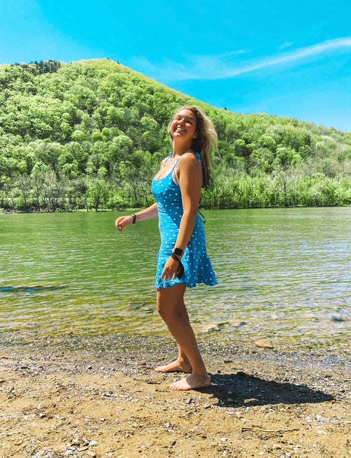 Smiling by river in front of mountain