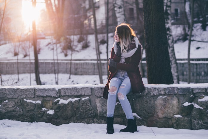 woman in winter clothing is sitting outside in the snow by freestocksorg?width=698&height=466&fit=crop&auto=webp