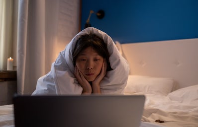 woman watching a movie in bed