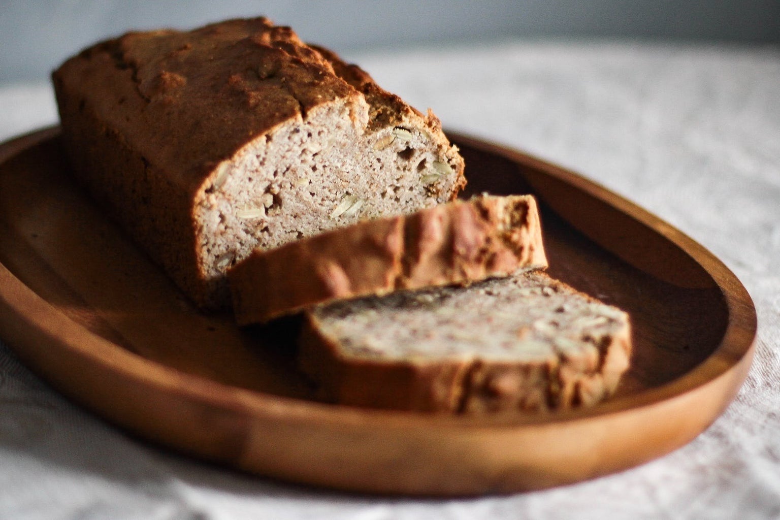 close-up of sliced loaf of bread on oval wooden plate