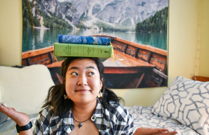 Woman with books balanced on head by Cassandra Shin?width=719&height=464&fit=crop&auto=webp