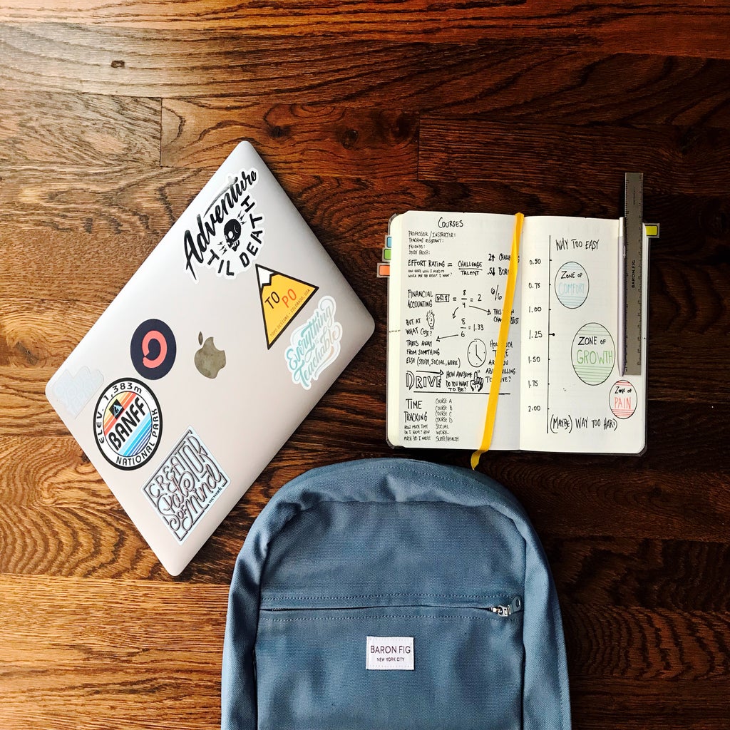 Image of laptop, backpack, and notebook on desk
