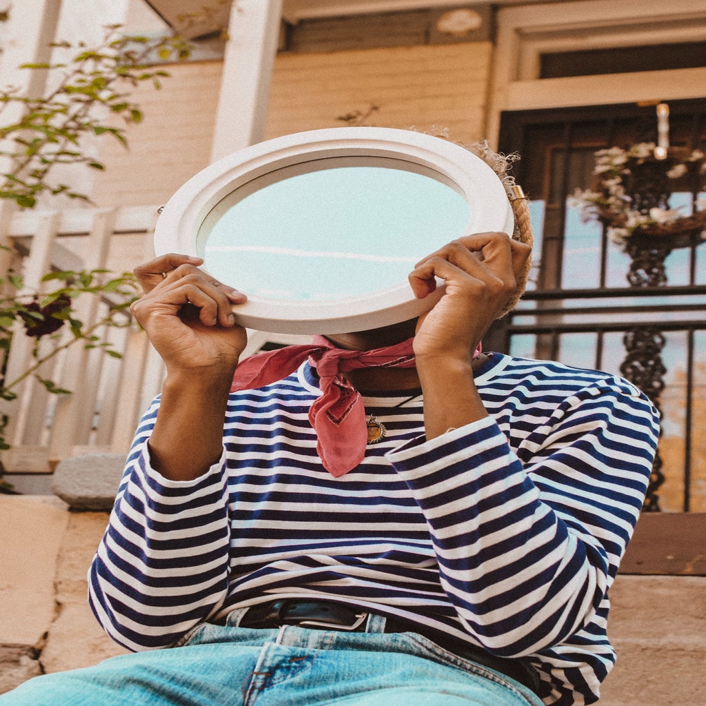 Person in a striped shirt has a plate in front of their face