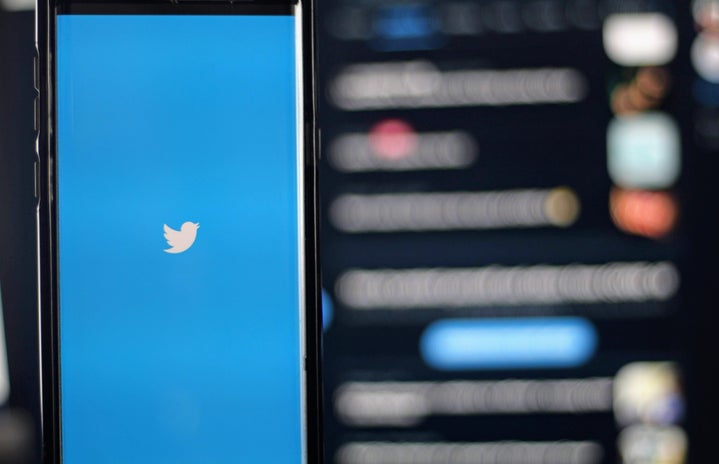 Twitter logo in front of a blurred screen
