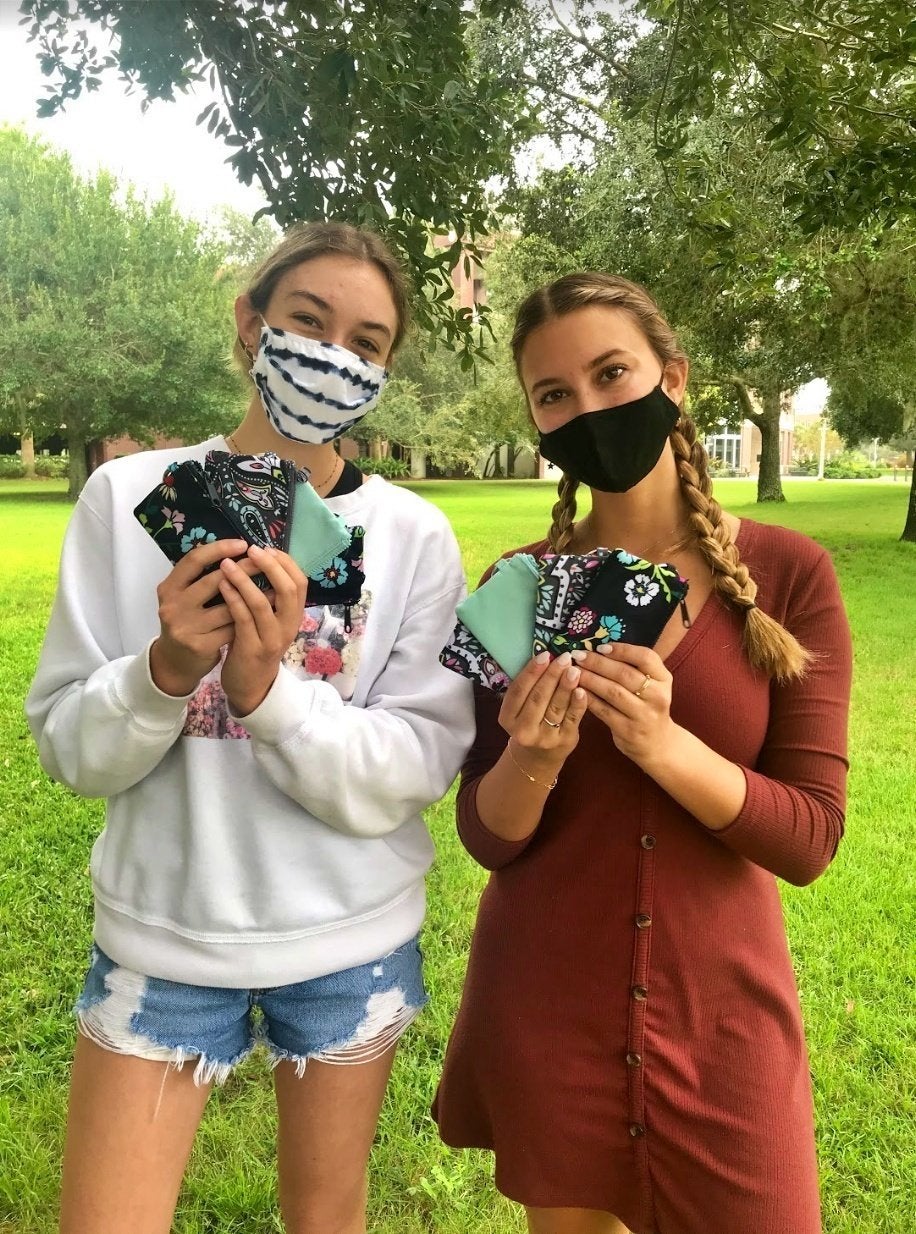 students holding wallets up to their faces
