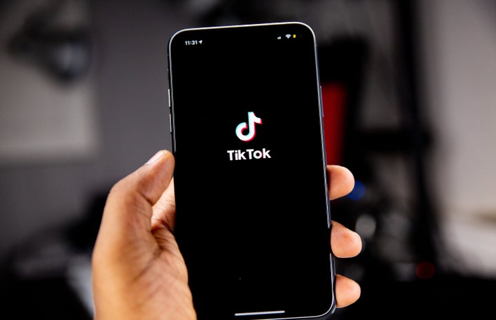 Person holding an iPhone running TikTok