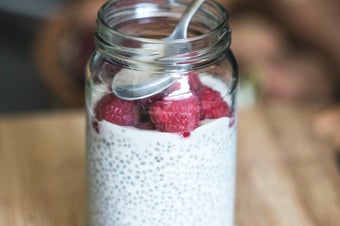 glass jar filled with chia seed pudding and raspberries