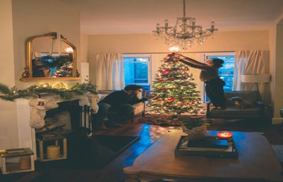 a couple decorating a Christmas tree