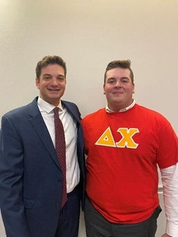 Ted standing next to a brother at a fraternity event