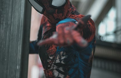 Spider man on a wall shooting a web