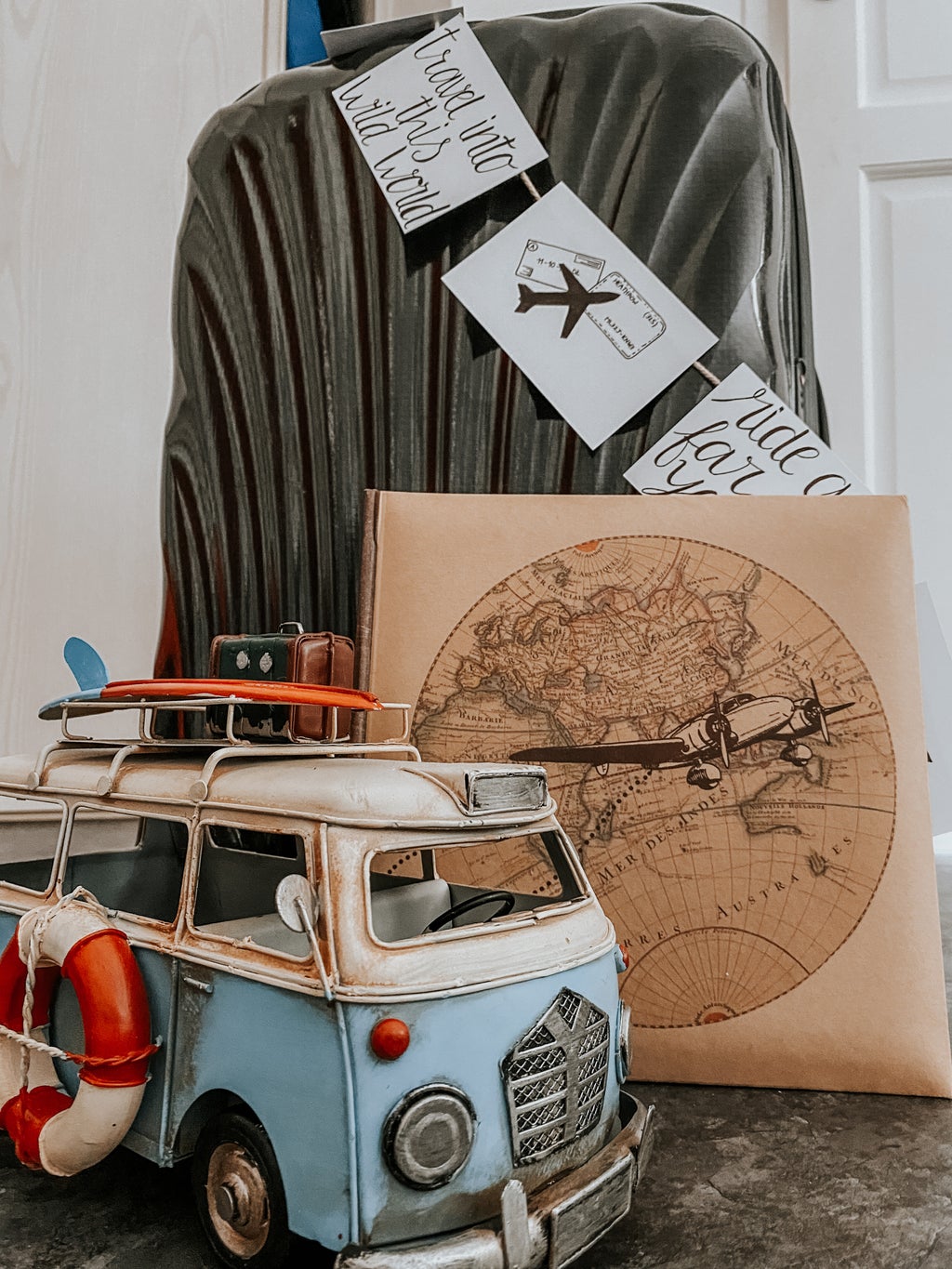 A suitcase with decoration about travel and a small van
