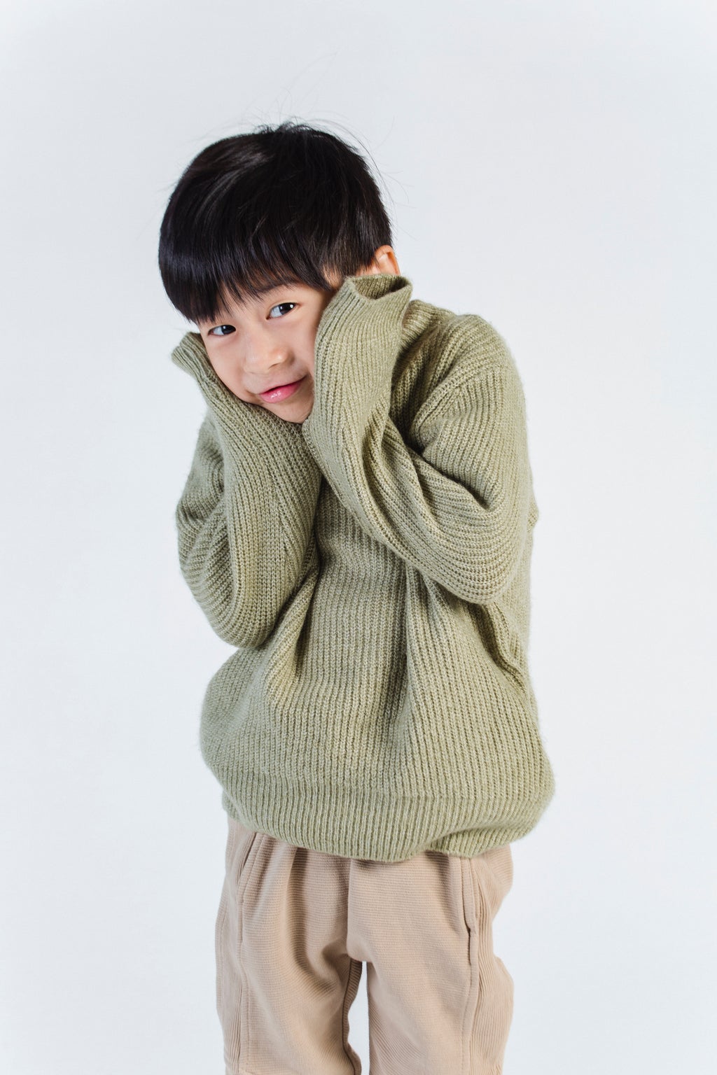 embarrassed young boy in green sweater