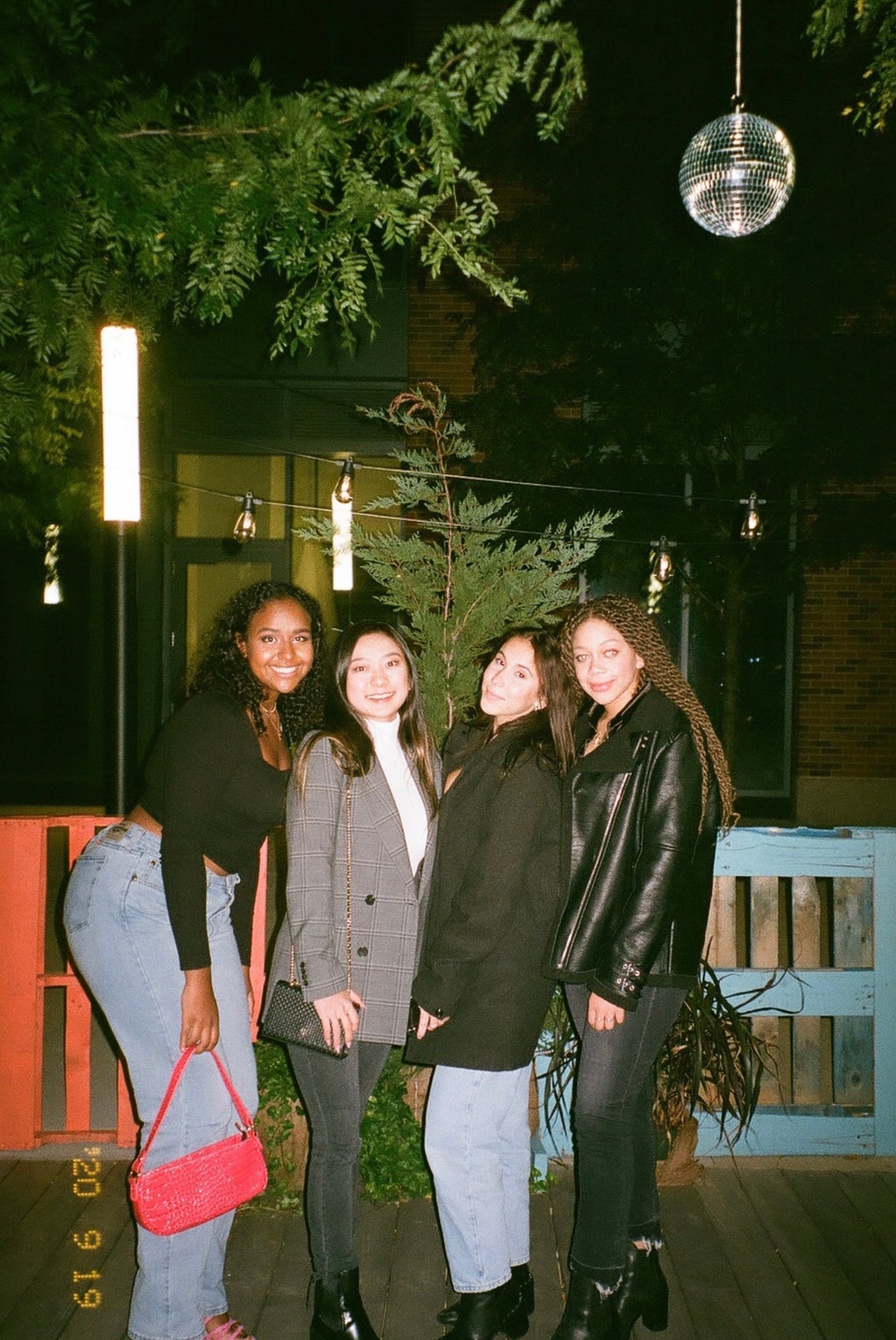 Four women standing at  night time