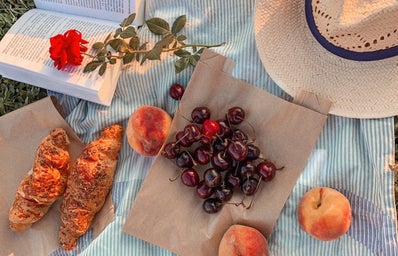 a picnic blanket set with cherries and pastries