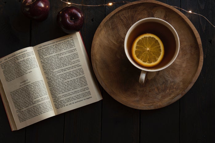 top view of open book with lemon in cup