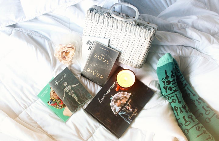 books, a candle, a purse, and a flower