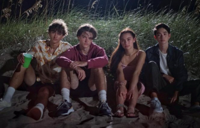 Foto del cast de la serie en una playa de noche