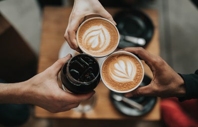 three people holding coffee