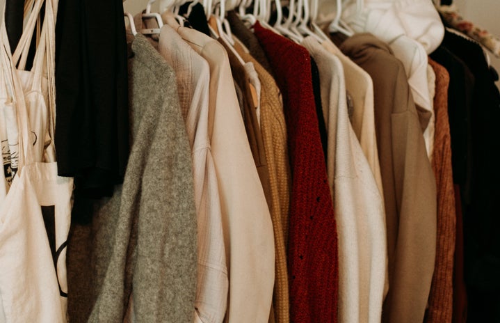 a clothing rack with sweaters and clothes on it