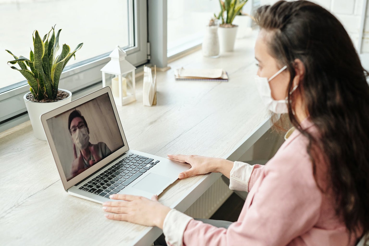 Woman in front of laptop with mask on