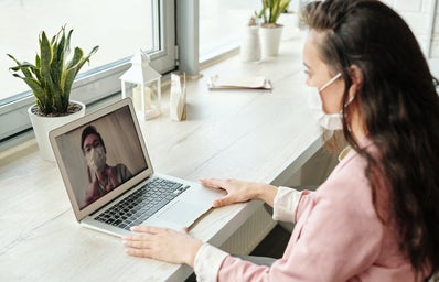 Woman in front of laptop with mask on